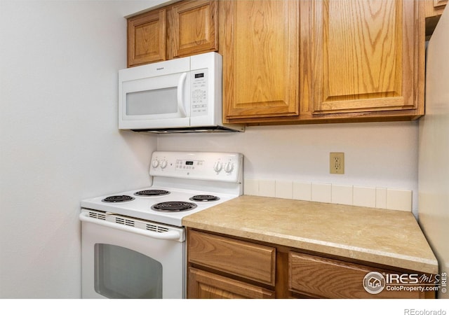 1155 S Saint Vrain Ave Unit U6, Estes Park, CO 80517 - kitchen with white appliances, light countertops, and brown cabinetry