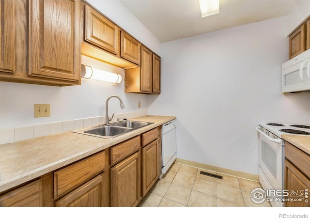 kitchen with light tile patterned flooring, sink, and white appliances