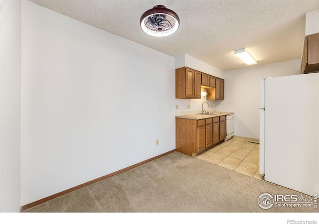 kitchen featuring light carpet, white appliances, a textured ceiling, and sink