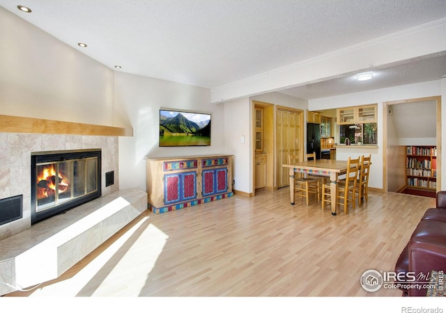 living room with a fireplace, hardwood / wood-style floors, and a textured ceiling