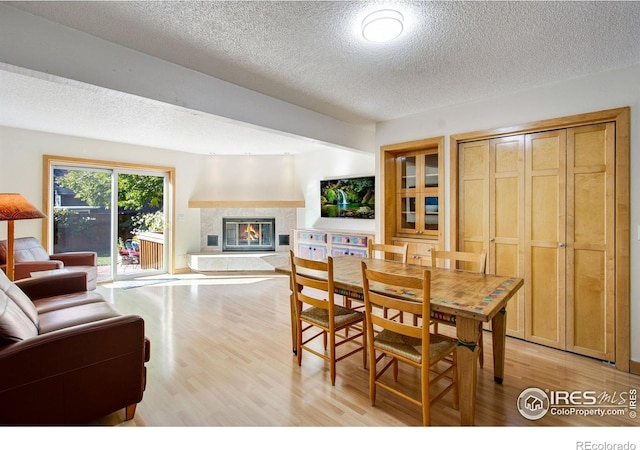 dining area featuring a textured ceiling and light hardwood / wood-style flooring