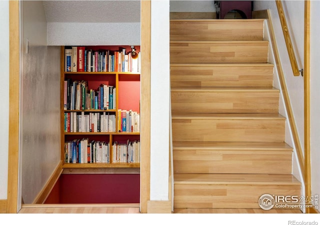 stairway featuring a textured ceiling