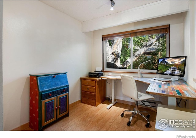 office area with light hardwood / wood-style floors and a textured ceiling