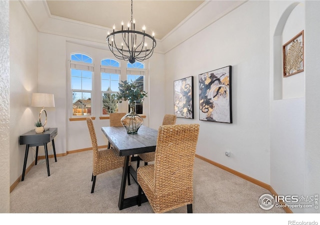 dining area featuring a chandelier, ornamental molding, and light carpet