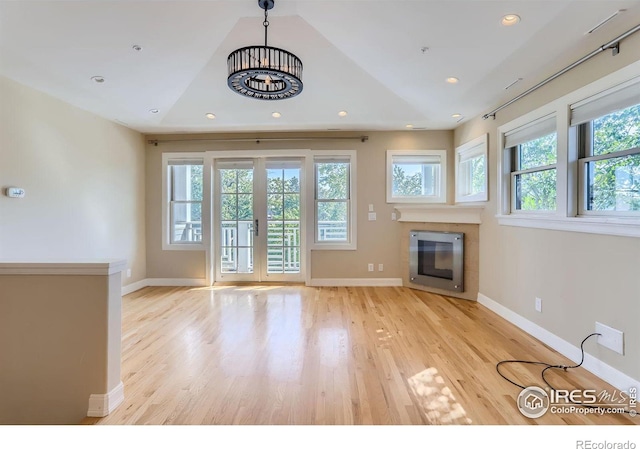 unfurnished living room with vaulted ceiling and light hardwood / wood-style floors