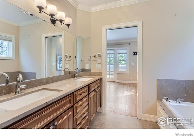 bathroom featuring crown molding, a healthy amount of sunlight, vanity, and a tub