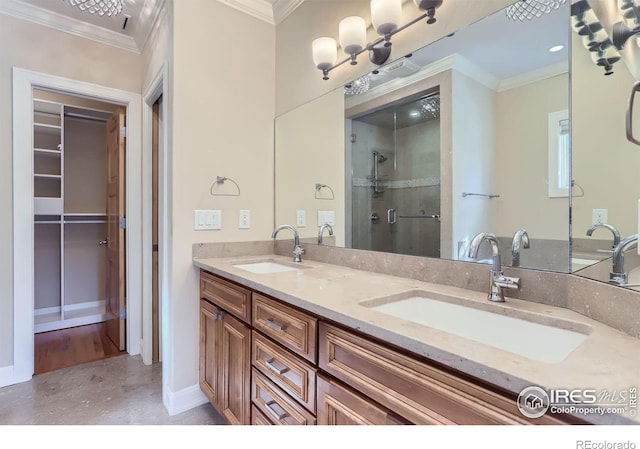 bathroom with ornamental molding, vanity, and a shower with shower door