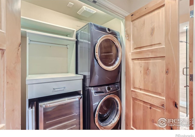 clothes washing area with stacked washer and dryer