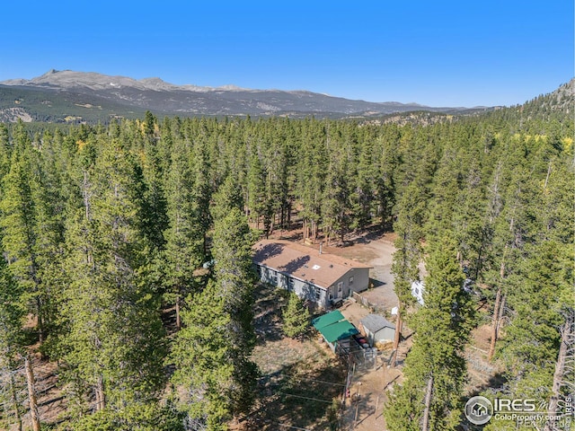 drone / aerial view featuring a mountain view and a wooded view
