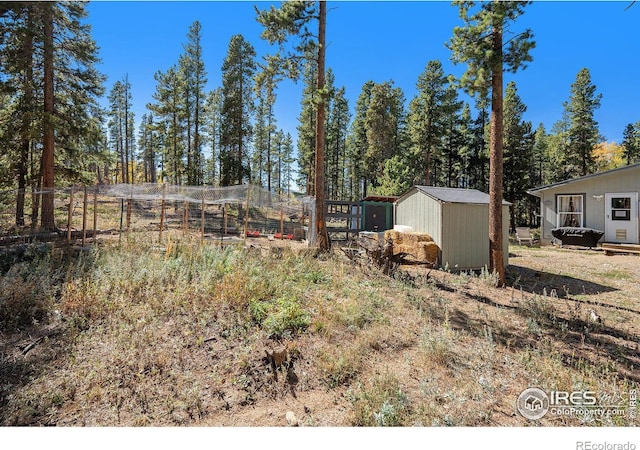 view of yard featuring fence, an outbuilding, and a storage shed