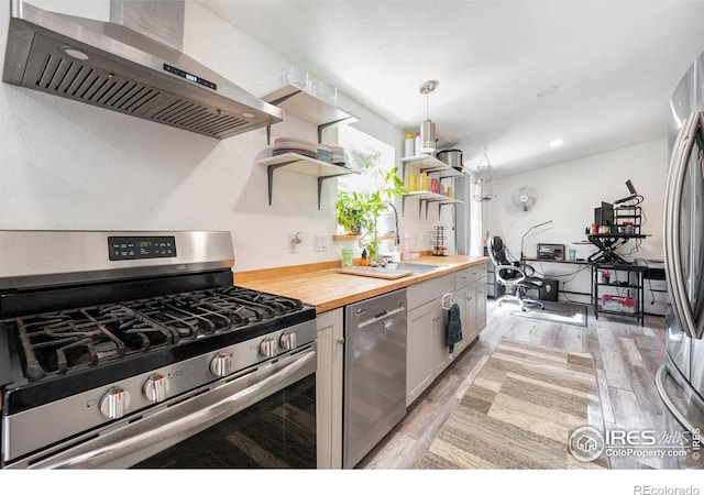kitchen featuring open shelves, a sink, butcher block countertops, stainless steel appliances, and ventilation hood