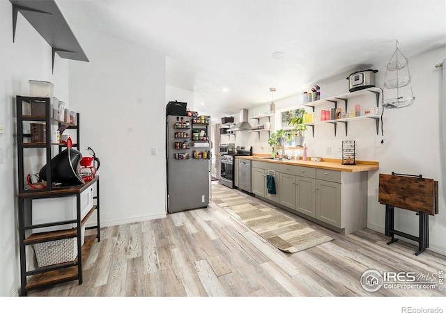 kitchen featuring light wood-type flooring, gray cabinetry, open shelves, wood counters, and appliances with stainless steel finishes