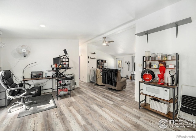 workout room featuring lofted ceiling, light wood-type flooring, a ceiling fan, and baseboards