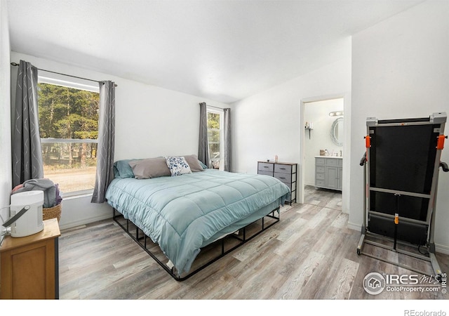 bedroom with light wood-style floors, lofted ceiling, and multiple windows