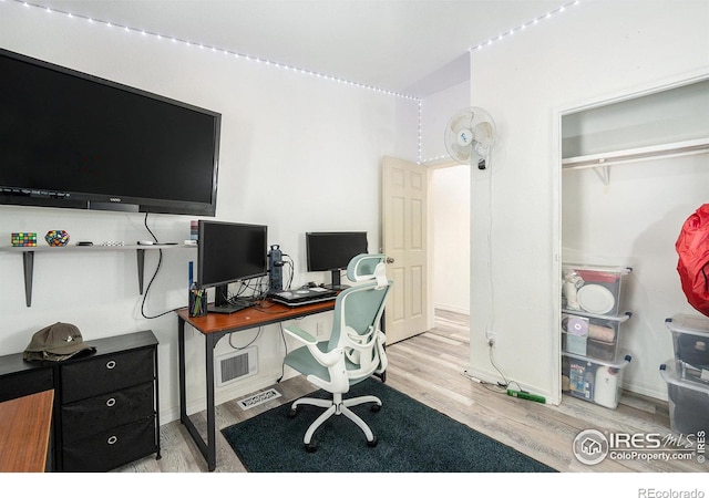 home office featuring wood finished floors, visible vents, and baseboards