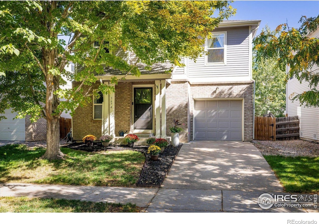 3674 Dexter St, Denver, CO 80207 - view of front facade with a garage, brick siding, and driveway