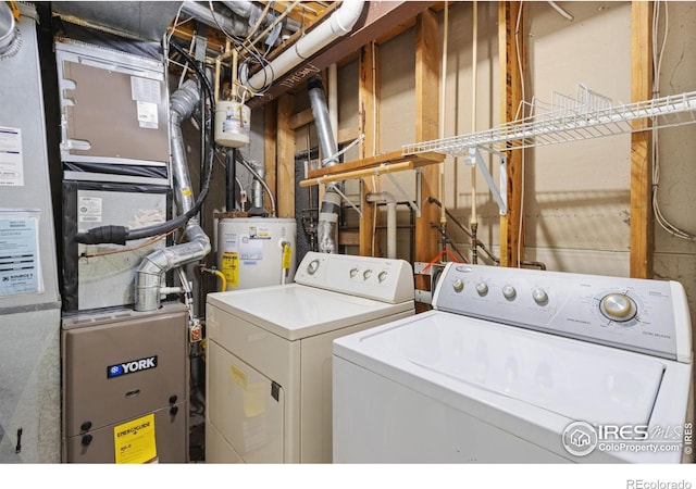 laundry area featuring washing machine and clothes dryer, heating unit, and water heater