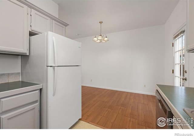 kitchen with dishwasher, an inviting chandelier, white fridge, pendant lighting, and light hardwood / wood-style floors