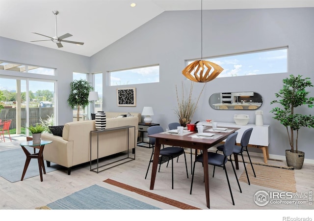 dining room with ceiling fan, light wood-type flooring, high vaulted ceiling, and a wealth of natural light