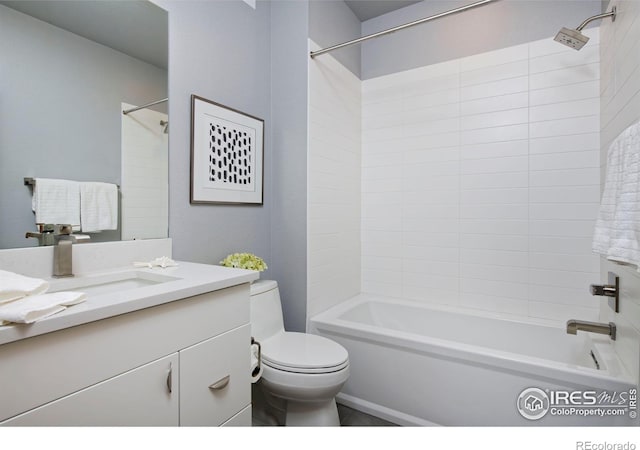 full bathroom featuring tiled shower / bath, vanity, and toilet