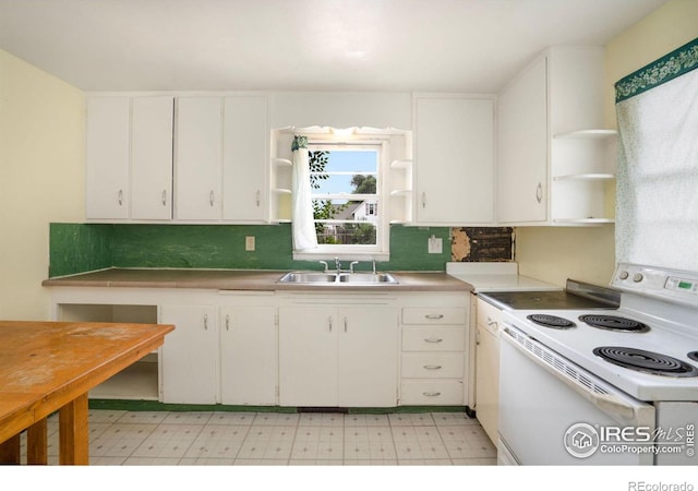 kitchen featuring decorative backsplash, white cabinets, electric stove, and sink