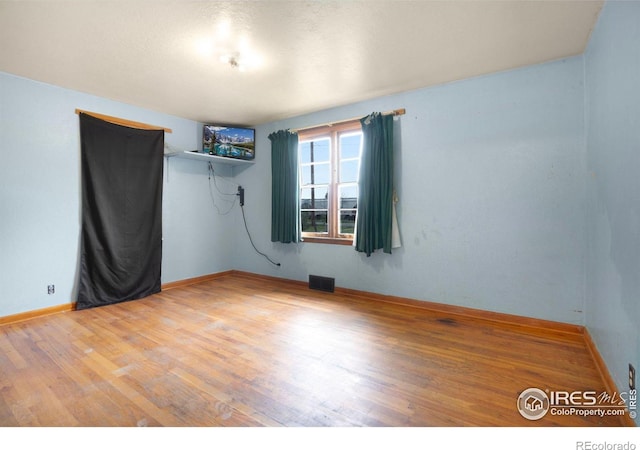 spare room featuring wood-type flooring