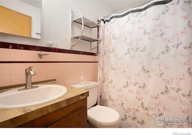 bathroom featuring a shower with curtain, vanity, tile walls, and toilet