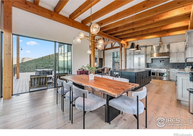 dining room featuring light hardwood / wood-style floors and beamed ceiling