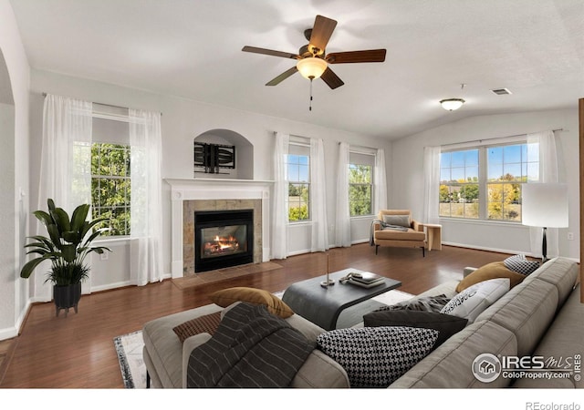 living room with a healthy amount of sunlight, dark wood-type flooring, and vaulted ceiling