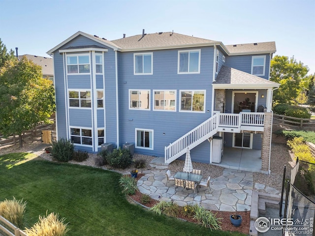 rear view of property featuring a patio and a lawn