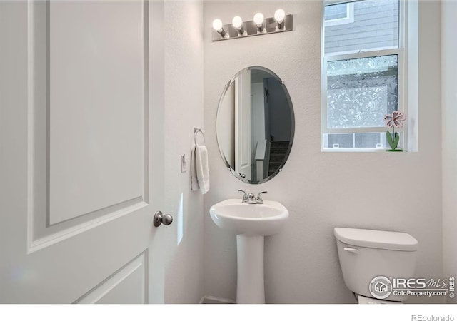 bathroom featuring sink, plenty of natural light, and toilet