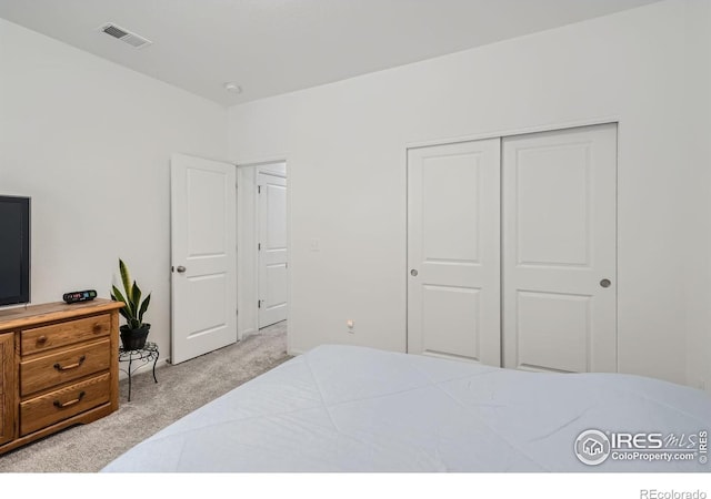 bedroom featuring light carpet and a closet