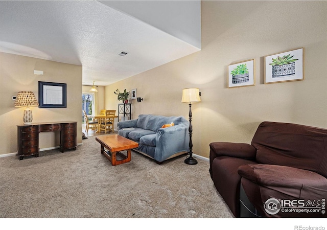 living room with a textured ceiling and carpet flooring