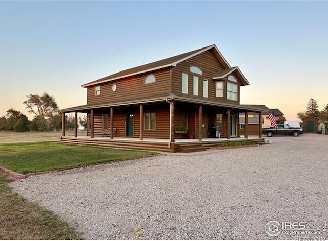 view of front of home with covered porch and a yard