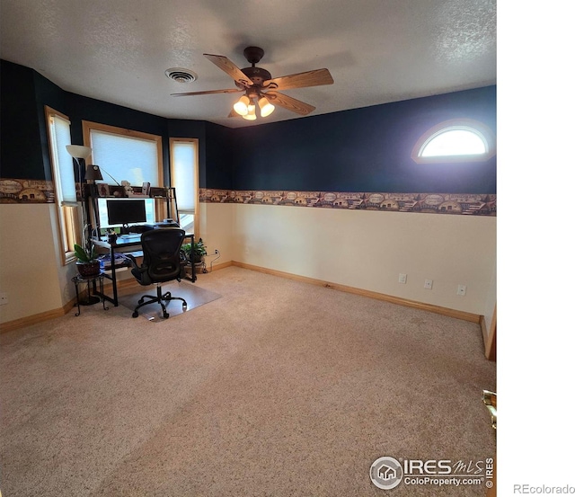 carpeted office featuring a textured ceiling and ceiling fan