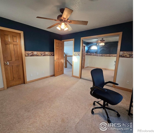 carpeted office space featuring ceiling fan