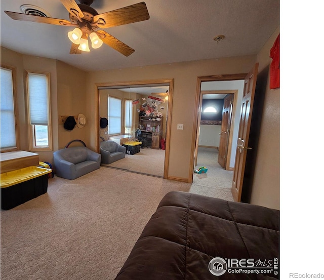 living room featuring light colored carpet and ceiling fan