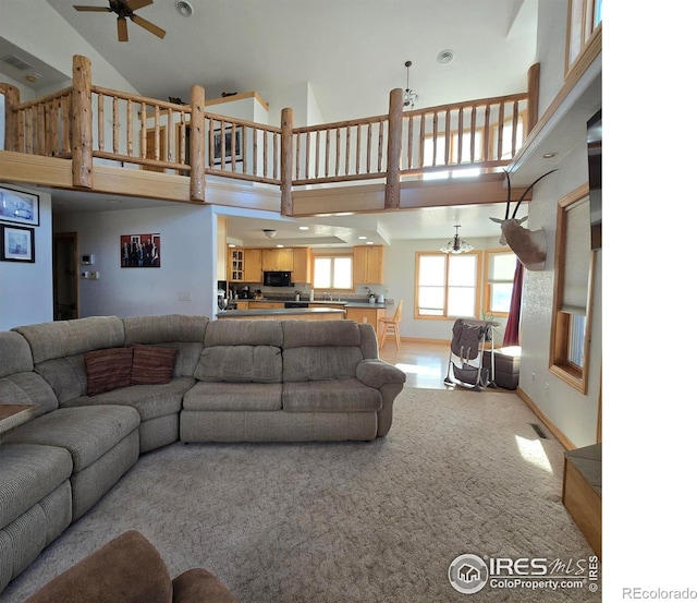 living room with carpet flooring, high vaulted ceiling, and ceiling fan