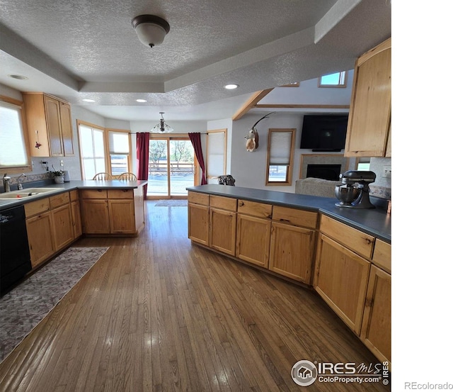 kitchen with black dishwasher, a raised ceiling, kitchen peninsula, and dark hardwood / wood-style flooring