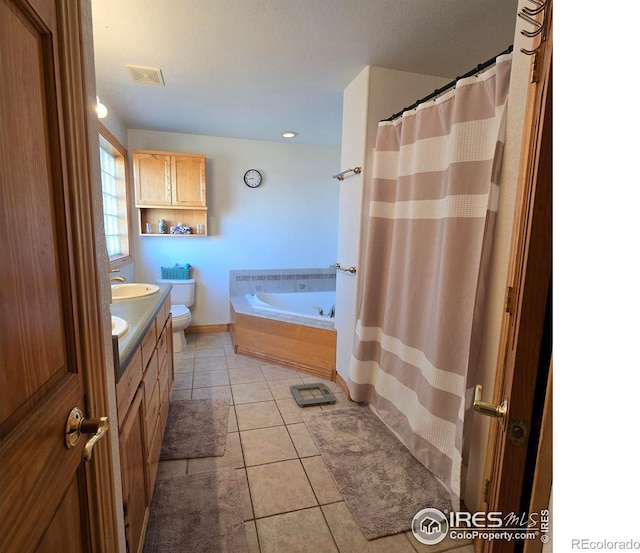 full bathroom featuring toilet, plus walk in shower, vanity, and tile patterned flooring