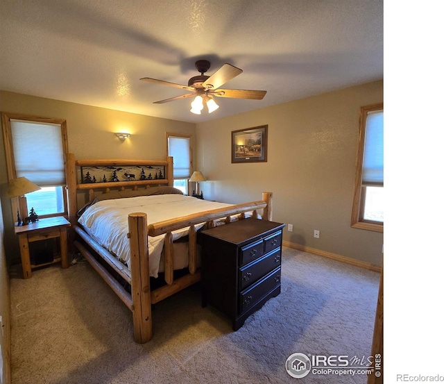 carpeted bedroom with a textured ceiling and ceiling fan