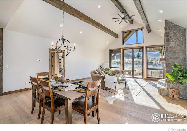 dining area with ceiling fan with notable chandelier, light wood-type flooring, beamed ceiling, and high vaulted ceiling