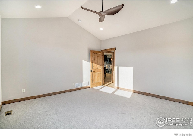 carpeted spare room with ceiling fan and high vaulted ceiling