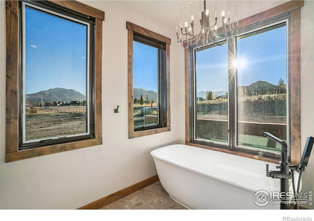 bathroom with a bath, a chandelier, and a mountain view