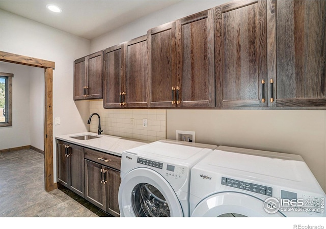 clothes washing area featuring cabinets, sink, and independent washer and dryer