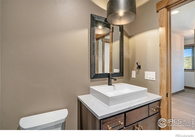 bathroom featuring hardwood / wood-style floors, vanity, and toilet