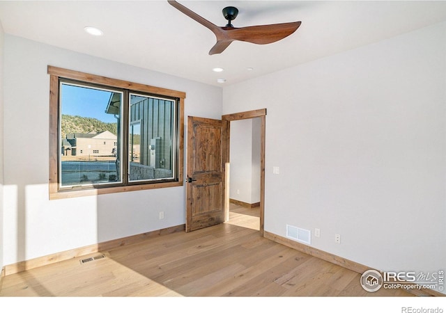 empty room with light hardwood / wood-style floors and ceiling fan