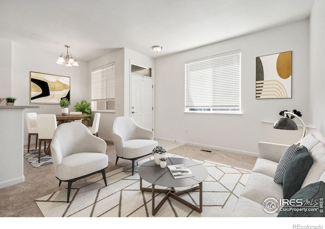 carpeted living room with a chandelier