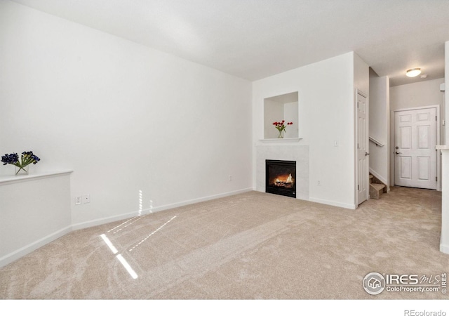 unfurnished living room featuring light carpet and a tile fireplace