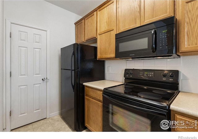 kitchen with black appliances, light tile patterned flooring, and backsplash